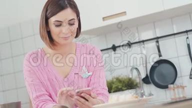 厨房里用智能手机的女人在社交媒体上<strong>发信息</strong>
